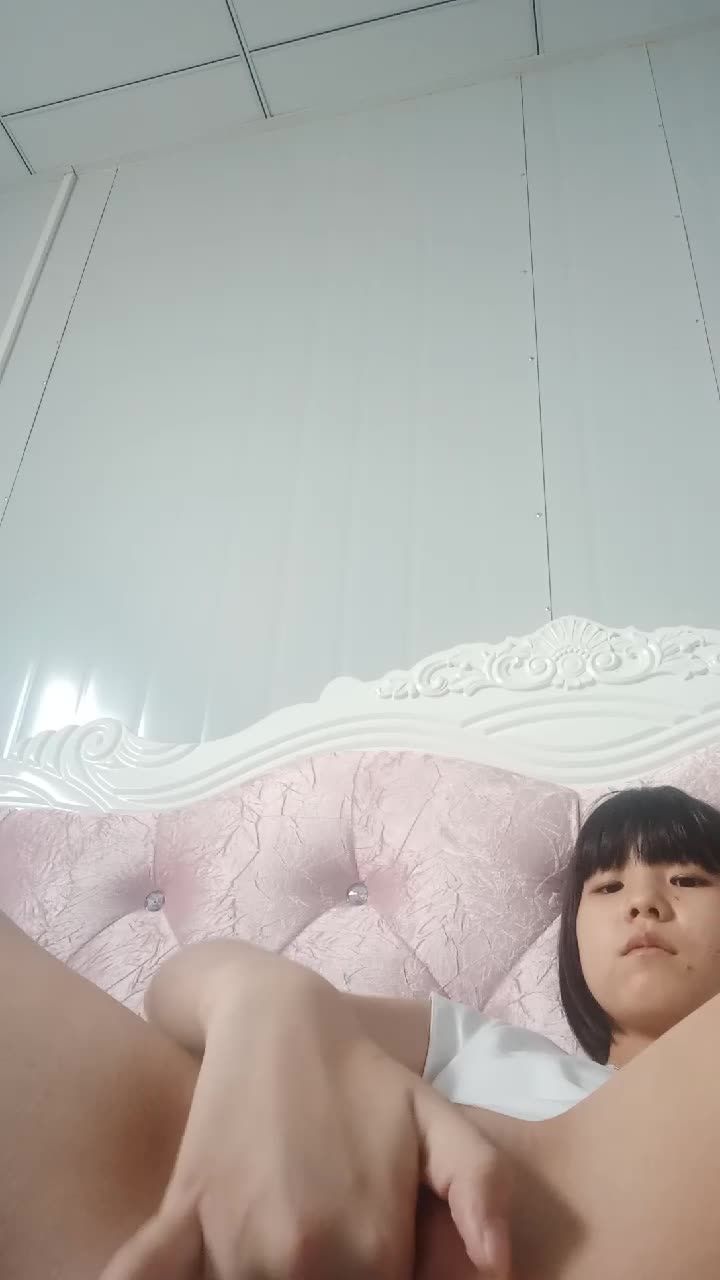 幼女一脸从容的在精致的床上用手指狂扣骚穴自慰视频